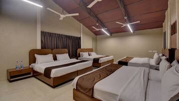 A hotel room with two beds, a wooden headboard, a nightstand, and a ceiling fan.