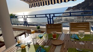 A table set for two with a view of the ocean and a cityscape. - Sunny Seaview Modern apt - Pool and Beach Access (Mogan)