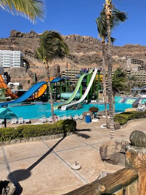Ein Resort mit mehreren Wasserrutschen, einem Poolbereich und einer Bergkulisse.