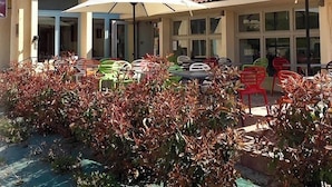 Hotel con terraza y sombrillas, llamado "Hotel de l'Abbaye Restaurant".