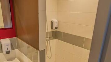 Une salle de bain avec une douche, un lavabo et un miroir.