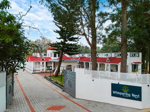 A hotel with a red roof, white walls, and a sign reading "Whispering Nest". - MGM Whispering Nest Yelagiri (Tirupattur)