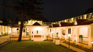 A well-lit building with multiple balconies and a covered outdoor area.