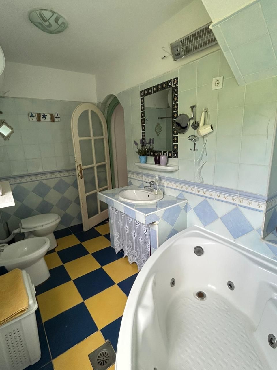 A bathroom with a checkered floor, a bathtub, a sink, and a toilet.