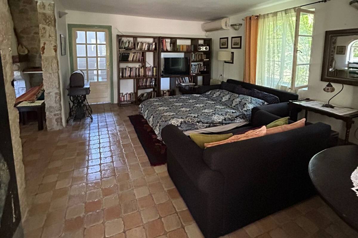 Una sala de estar acogedora con una cama grande, un televisor, una estantería y una chimenea de piedra.