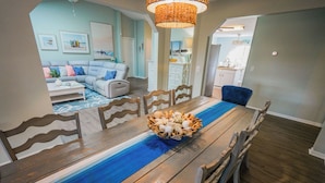 A dining area with a wooden table, blue runner, and a centerpiece of eggs. - Coastal Getaway with game room pool hot tub & inlaw suite in heart of Sebastian (Sebastian)