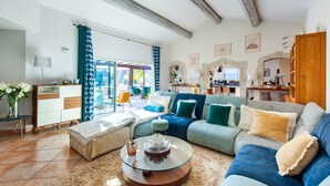 A spacious living room with a large sofa, a glass coffee table, and a view of the outdoor patio. - Beautiful home in Graveson (Graveson)