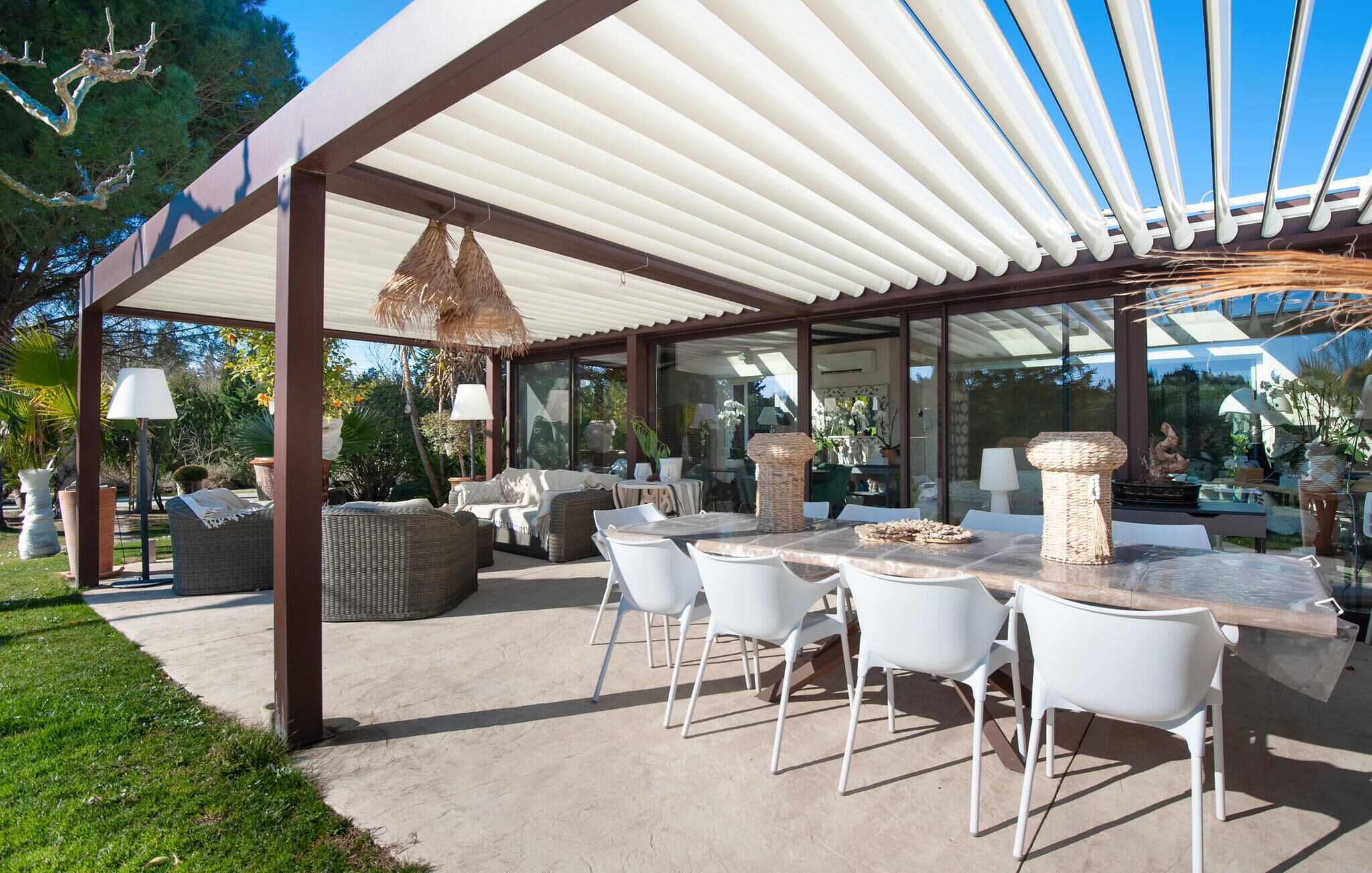 An outdoor patio with a covered seating area, a dining table, and chairs.