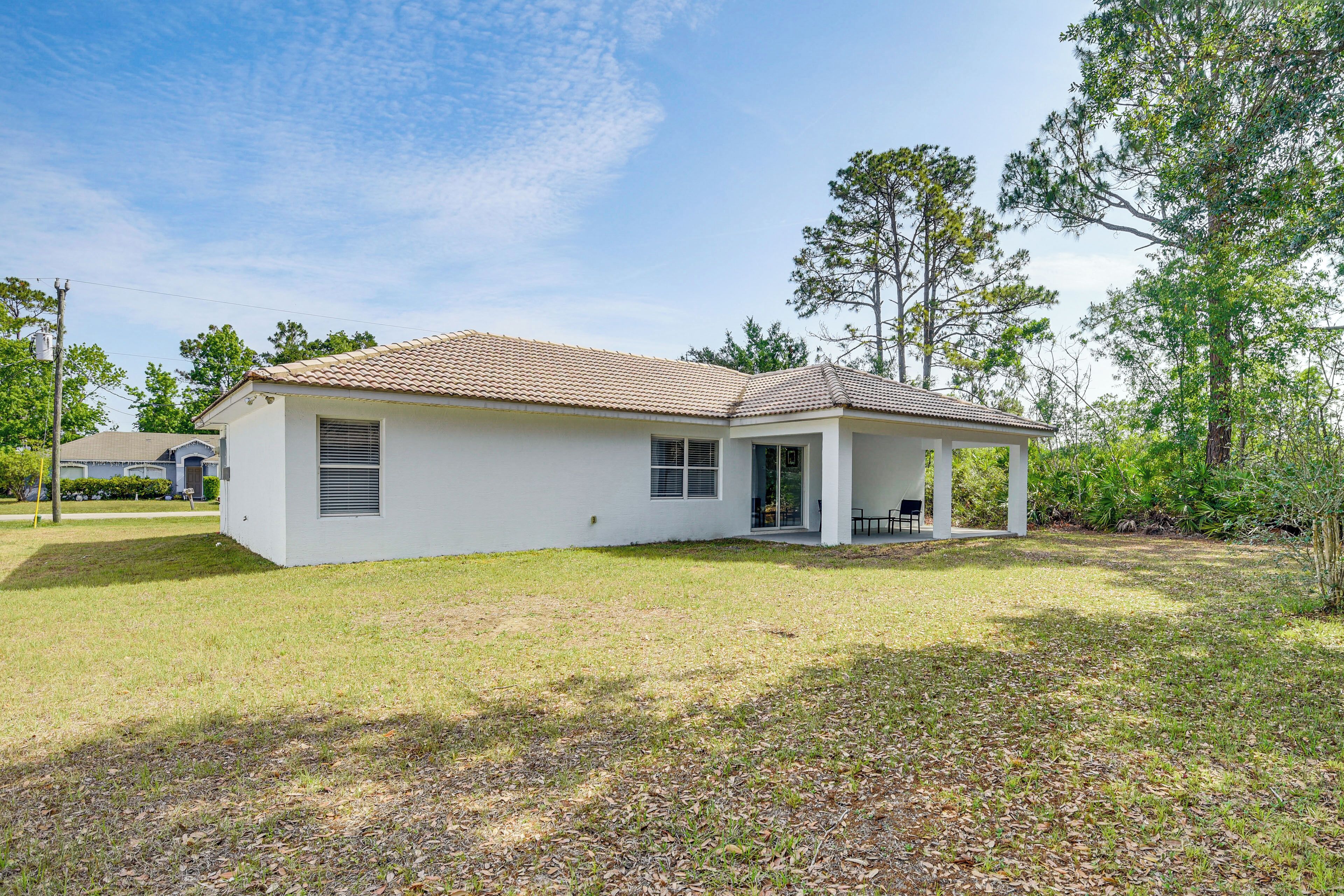 A single-story house with a tiled roof, a covered porch, and a well-maintained lawn.