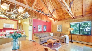 A wooden interior with a dining area, sofas, a fireplace, and a large window. - < 2 Blocks to Lake Tahoe: Family Home Near Skiing (Homewood)