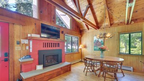 A wooden interior with a fireplace, a dining table, and large windows. - < 2 Blocks to Lake Tahoe: Family Home Near Skiing (Homewood)
