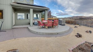 Une maison dotée d’un patio couvert, d’une table à manger avec des chaises et offrant une vue sur le paysage environnant.