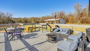 Eine Terrasse mit Gartenmöbeln, einem Feuerkorb und Blick auf ein Gebäude im Hintergrund.