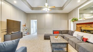 Ein geräumiges Wohnzimmer mit einer Eckcouch, einem Couchtisch und einem Flachbildfernseher.