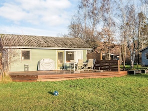 A single-story house with a porch, a covered grill, and a small deck. - 4 Person Holiday Home in Knebel (Knebel)