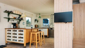 A kitchen with wooden cabinets, a bar area, and a large window.