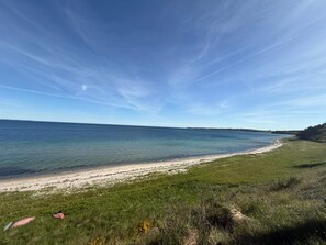 A coastal landscape with a clear sky, a sandy beach, and grassy areas. - 4 Person Holiday Home in Knebel (Knebel)