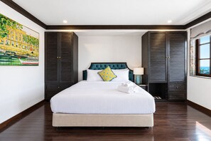 Ein Hotelzimmer mit einem großen Bett, einem dunklen Holzschrank, einem Bild an der Wand und einem Fenster mit Blick.