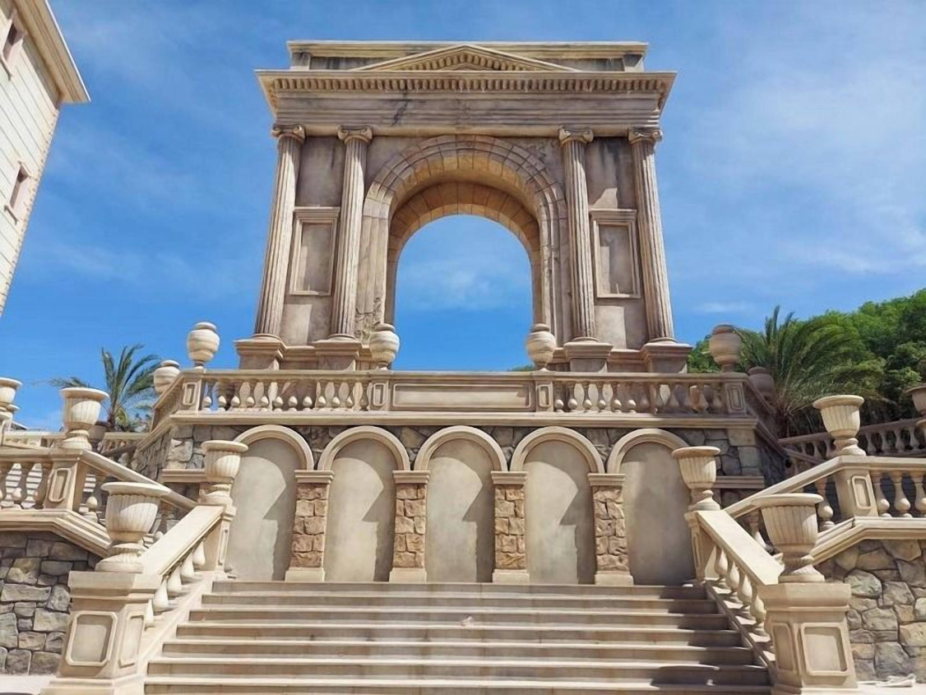 A grand entrance with a large archway, stone steps, and balustrades.