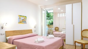 A bedroom with a bed, a chair, a wardrobe, and a painting on the wall. - Holiday House Genoveffa (Massa Lubrense)