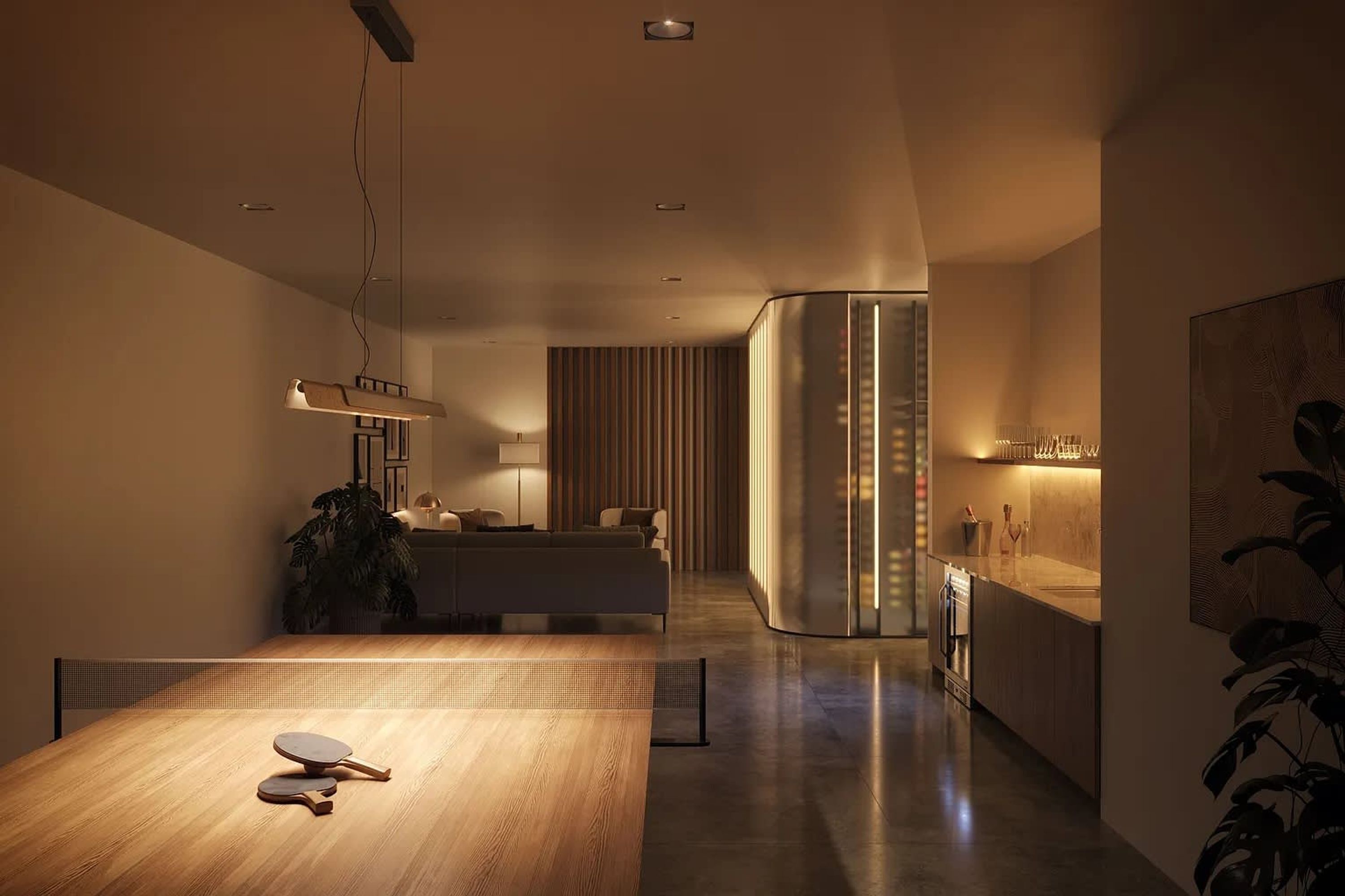 A modern kitchen with a wooden dining table, a sofa, and a kitchen island.