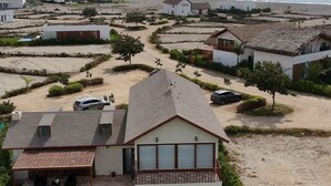 Un barrio residencial con casas, piscina y una playa al fondo.