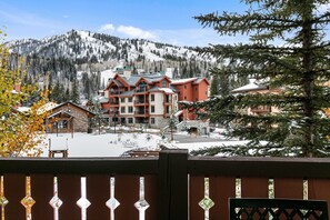 Un hotel con diversi piani, un paesaggio innevato e montagne sullo sfondo.