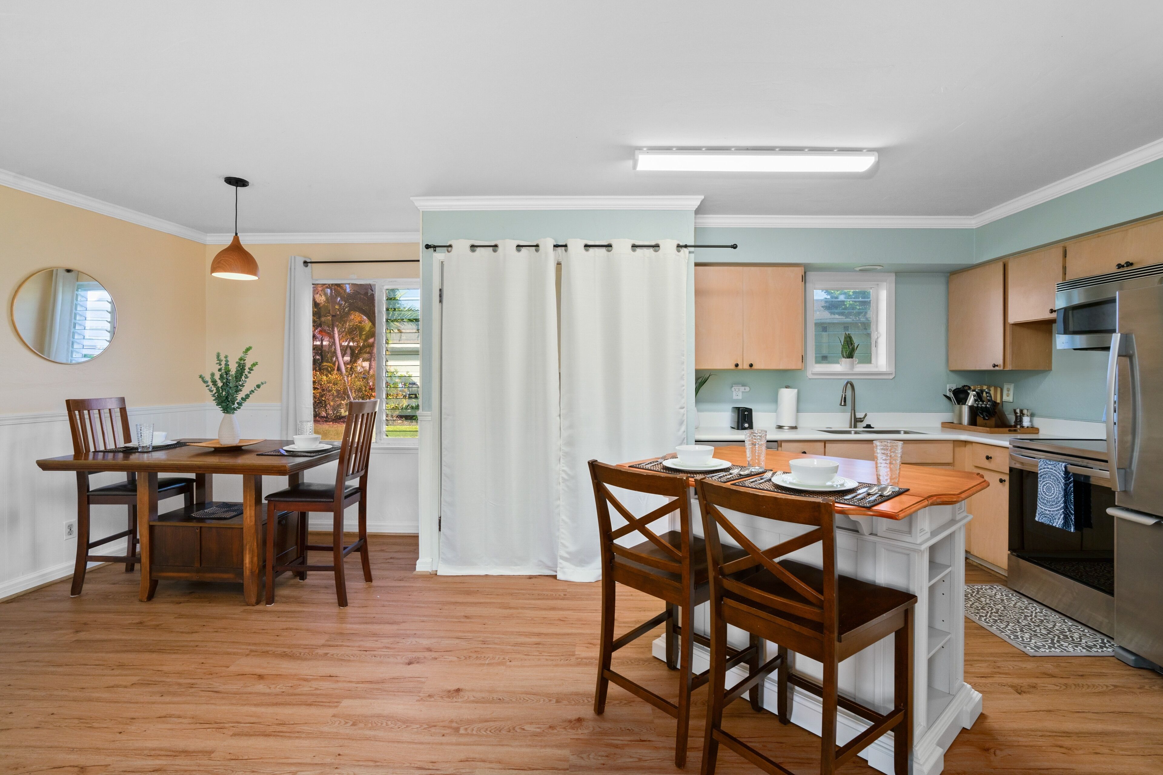 Una cucina moderna con isola centrale, tavolo da pranzo in legno e sedie.