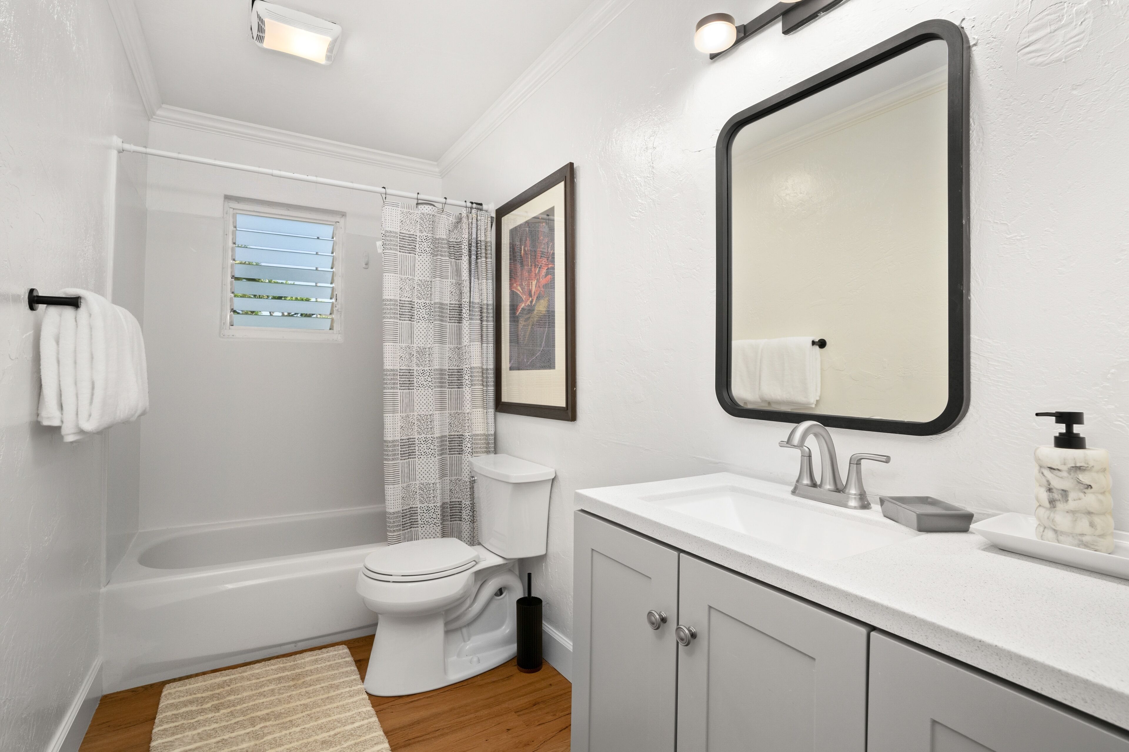 A modern bathroom with a bathtub, toilet, and sink.