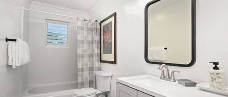 A modern bathroom with a bathtub, toilet, and sink.