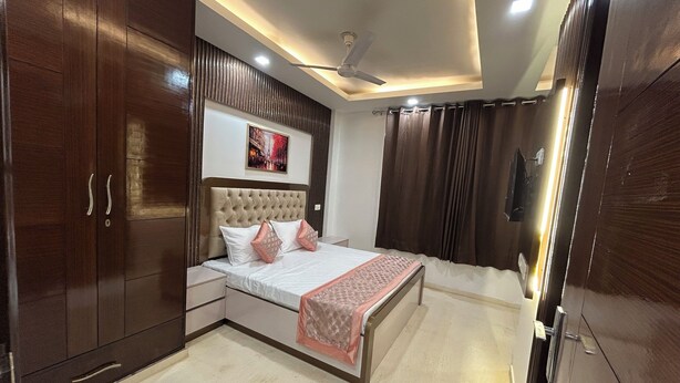 Ein Schlafzimmer mit einem großen Bett, einem Kleiderschrank, einem Deckenventilator und einem Bild an der Wand.