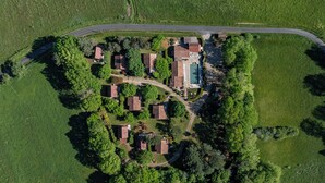 Vista aèria d'una zona residencial amb diverses cases, una piscina i un carrer corbat.