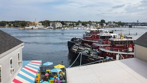 A waterfront dock with a red boat named 'Crown Point' and a white building with a striped awning. - Tugboat Vista 2 Bedroom Downtown Portsmouth (Portsmouth)