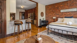 Una habitación con cama, escritorio y zona de cocina.