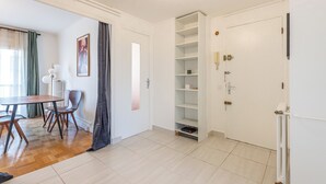 Et moderne værelse med spiseplads, en indbygget reol og en radiator.
