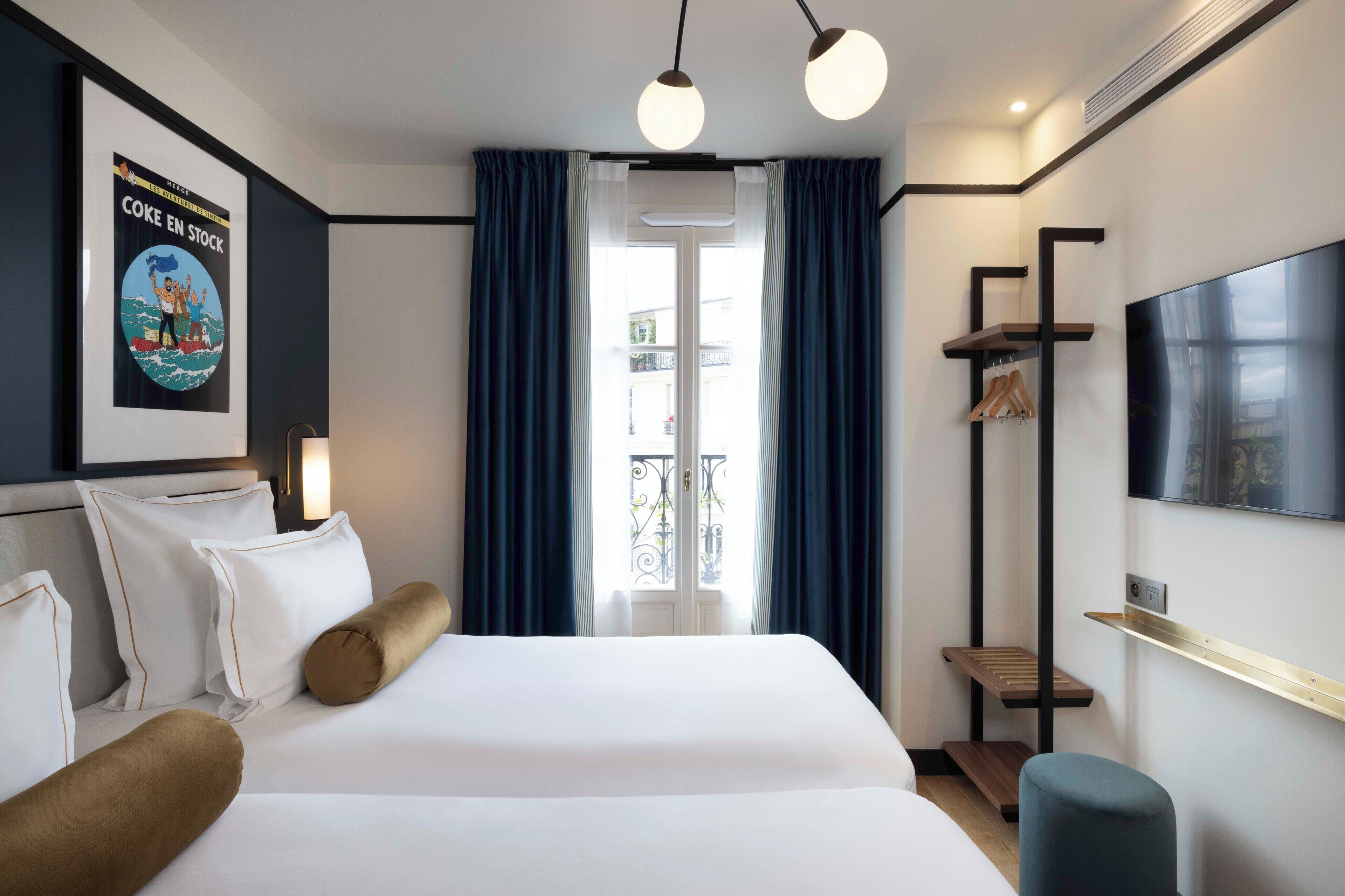 A modern hotel room with a large bed, a TV mounted on the wall, and a window with curtains.
