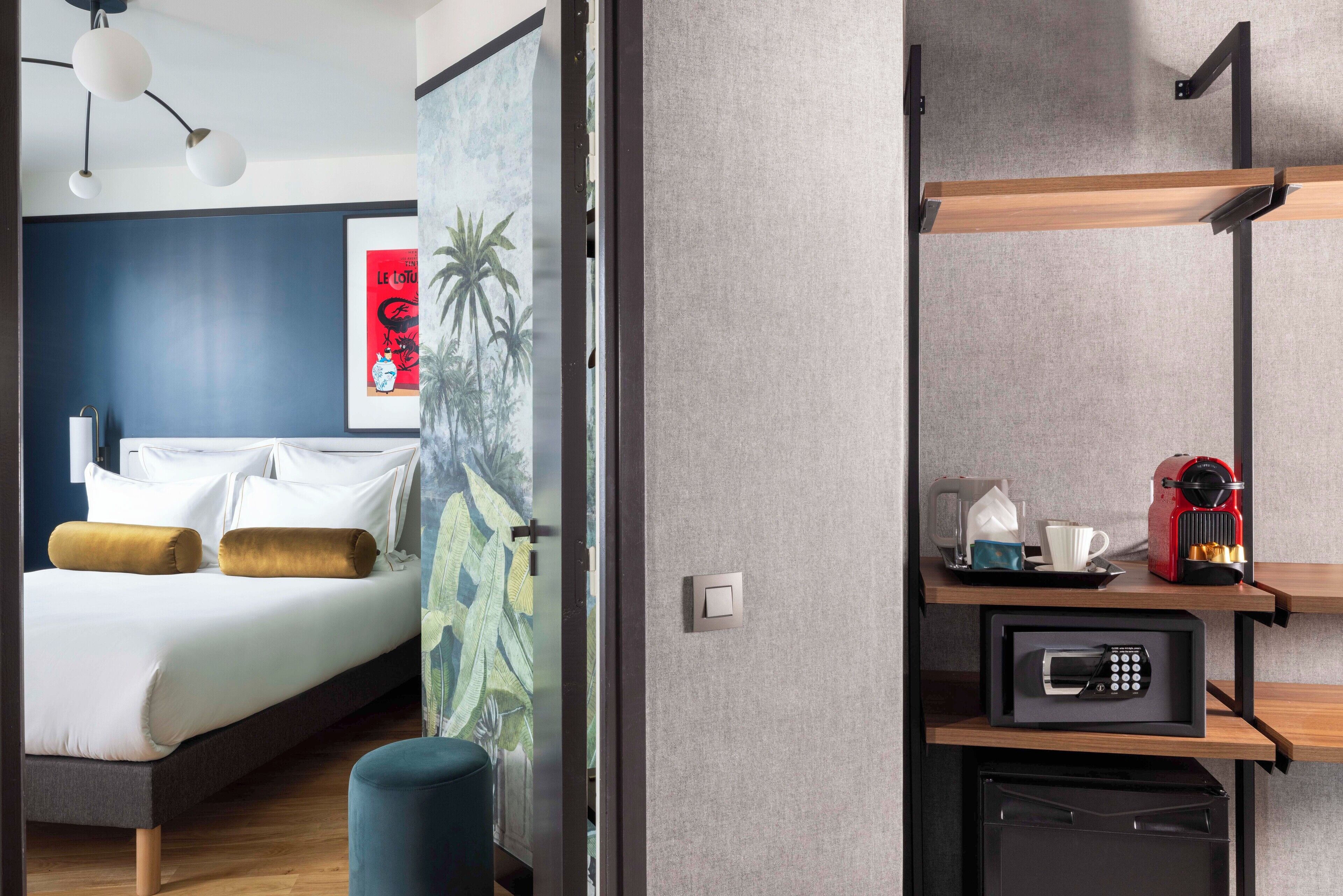 A modern hotel room with a bed, a coffee machine, and a microwave on a shelf.