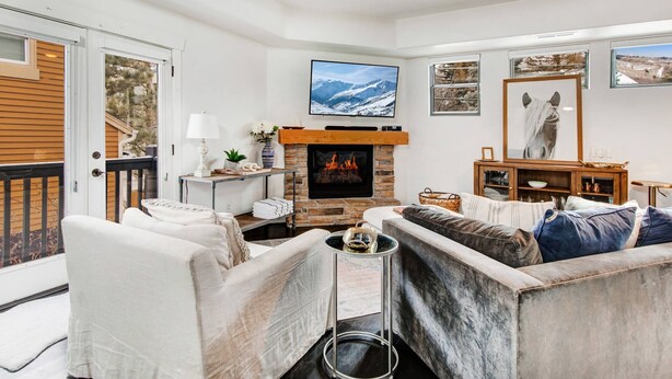 A cozy living room with a fireplace, comfortable seating, and artwork on the walls.