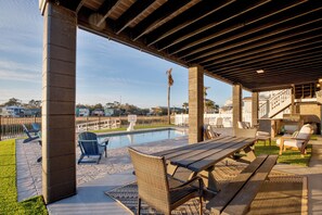 An outdoor patio area with a pool, seating, and a barbecue setup.