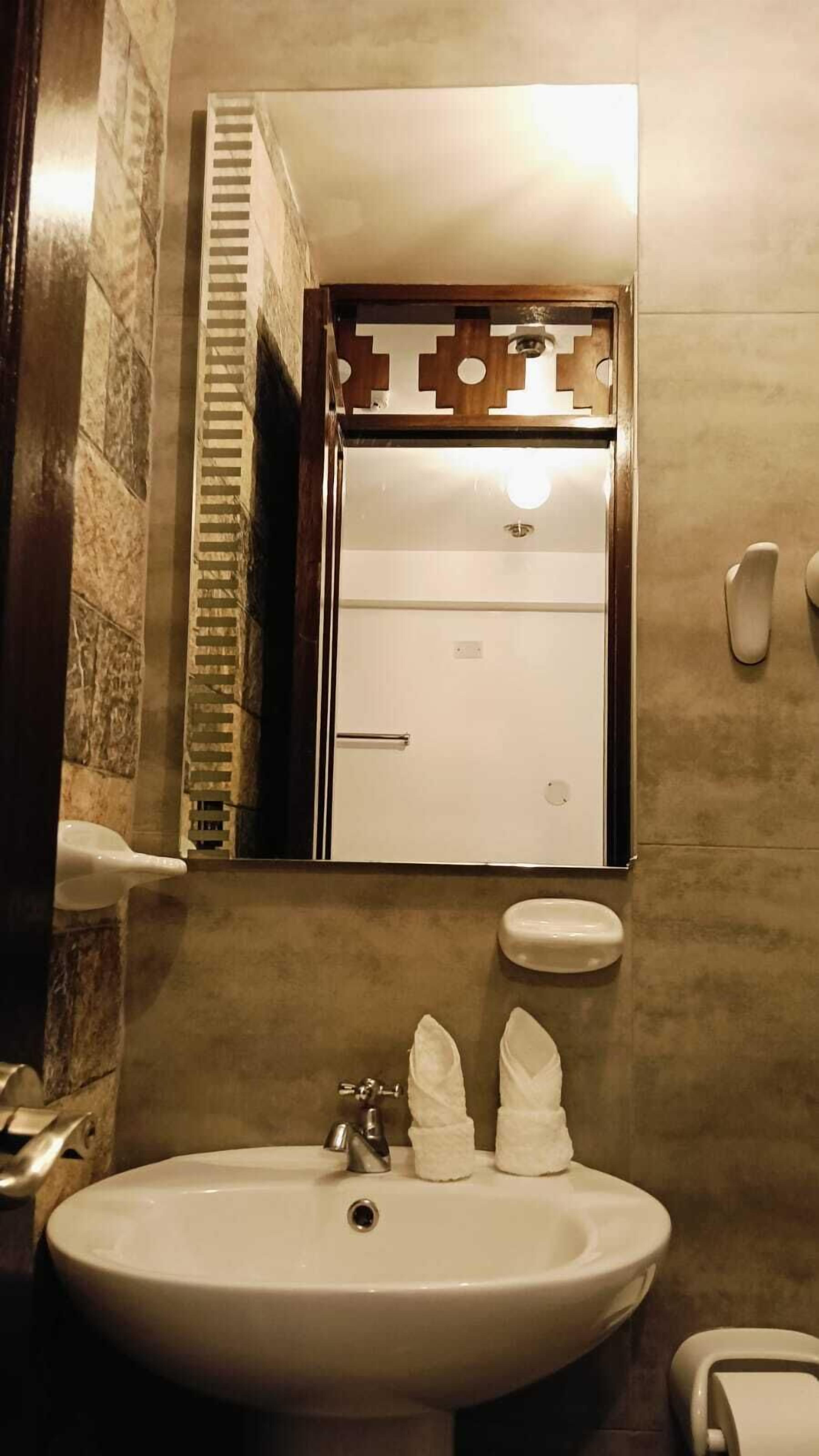 Een badkamer met een witte wastafel, een spiegel en een toilet.