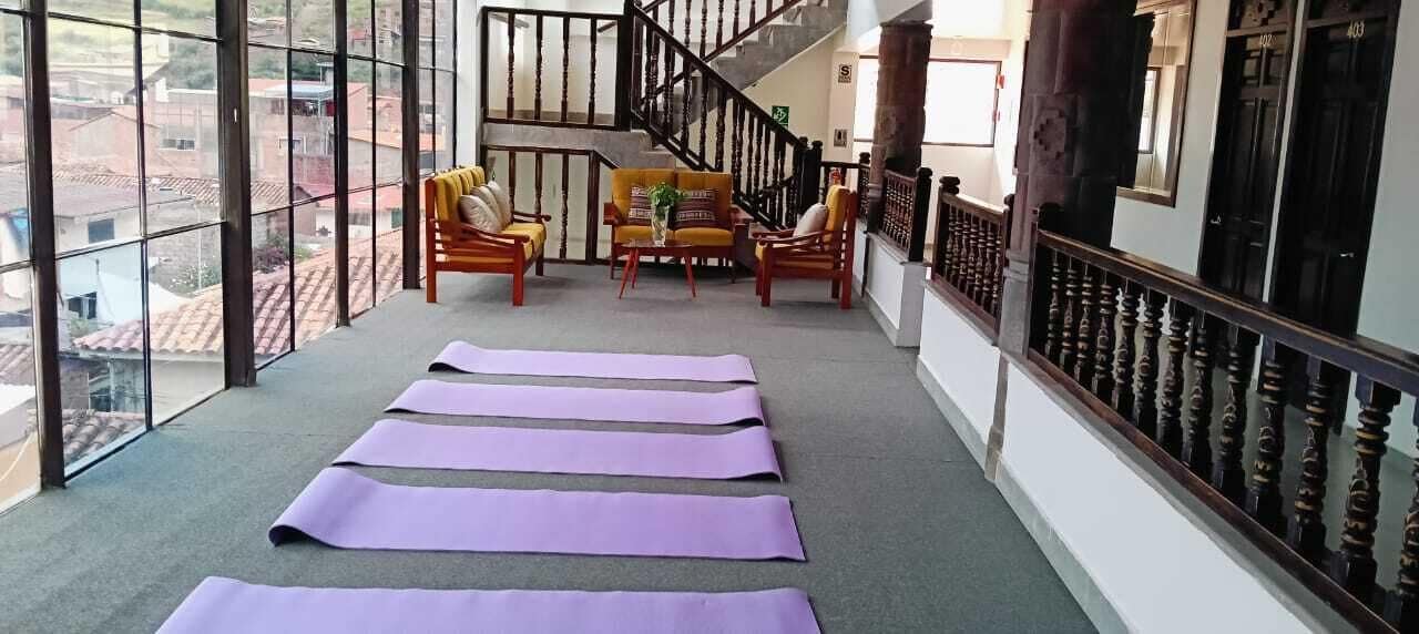 A balcony with yoga mats, a staircase, and a seating area with cushions.