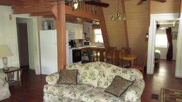 A cozy living room with a floral sofa, a wooden coffee table, and a ceiling fan.