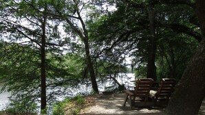 Un camping tranquilo junto al lago, con mesas y sillas de picnic.