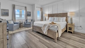Un dormitorio con una cama de madera, dos mesitas de noche, un ventilador de techo y una ventana con cortinas.