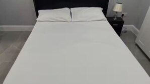 A single bed with white bedding, a black nightstand with a lamp, and a tiled floor. - Place to stay in Erith (Erith)