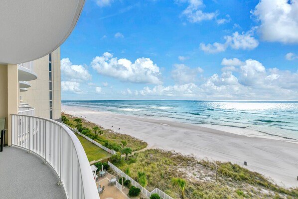 A balcony with a view of a beach and ocean.