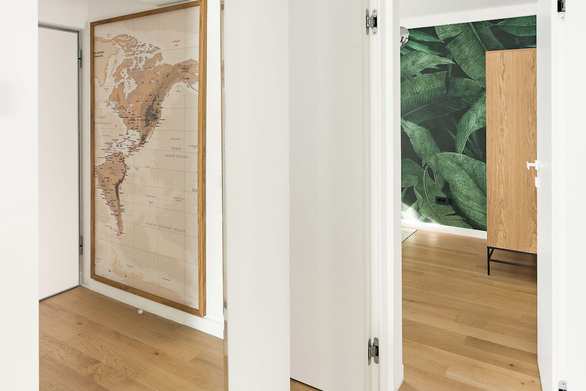 A room with wooden flooring, white walls, and a large map on one wall.