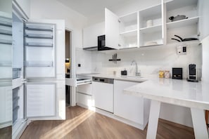 Enjoy meal preparation in this well-equipped kitchen with dishwasher, large refrigerator, and spacious countertop.