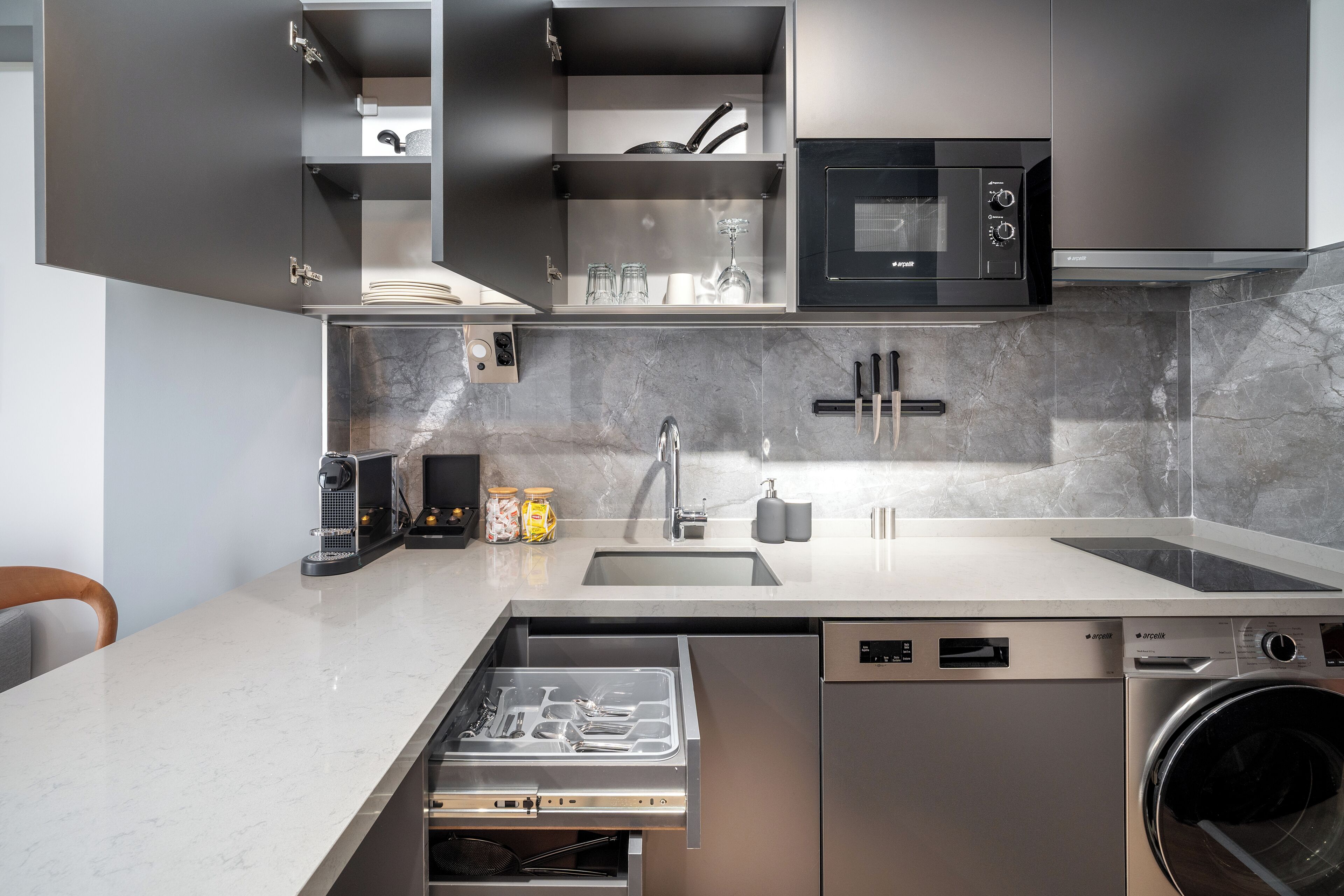 A modern kitchen with a built-in dishwasher, a microwave, and a sink.