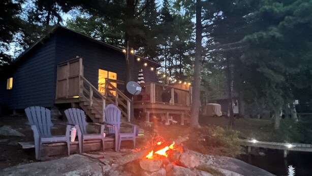 Une cabane dotée d’une terrasse, d’un espace salon extérieur et d’un foyer.